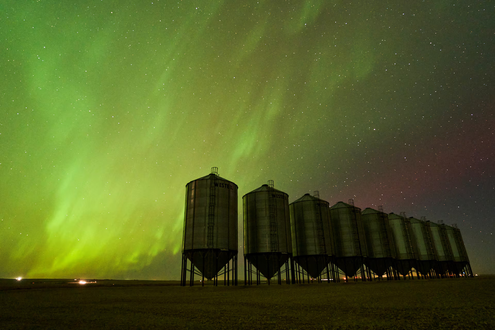 Northern lights over steel grain bins